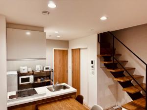 a kitchen with a sink and a stair case at Niseko Purr 203 in Ōmagari