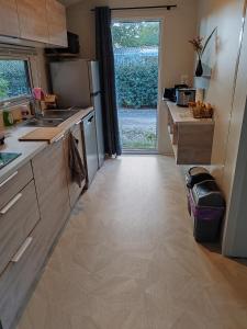 eine Küche mit einem Kühlschrank und eine Tür zum Hof in der Unterkunft Cottage Les 2 Chardon in La Teste-de-Buch