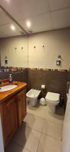 ein Bad mit einem WC, einem Bidet und einem Waschbecken in der Unterkunft El encanto del lago in San Carlos de Bariloche
