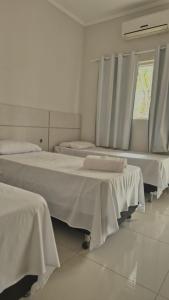 a room with two beds and a window at GRAN HOTEL in Três Lagoas