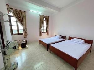 a room with two beds and a fan in it at Thanh Dat 1 Hotel in Bắc Ninh