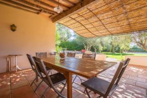 une table et des chaises en bois sur une terrasse dans l'établissement Villa familiale la Croix-du-Sud, à La Croix-Valmer