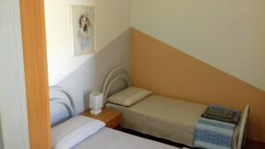 a small room with two beds and a picture on the wall at Casa Maria Teresa in Cardedu +41 photos
