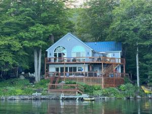 a house with a large deck on the water at Four Season Ski, Lake, And Golf Chalet on Lake Rescue in Tyson