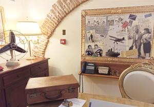 a room with a desk with a mirror and a table with a lamp at Blao boutique hotel in Oristano