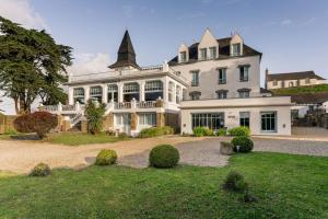 a large white house with a turret at Hotel Restaurant Spa du Tumulus Carnac in Carnac