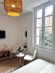 a bedroom with a bed and a table and a window at Le Saphir in Toulouse