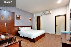 una camera d'albergo con un letto e una scrivania di S79 Hao Tin Hotel ad Ho Chi Minh