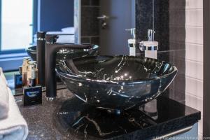 a bathroom with a glass bowl sink on a counter at Amber Suite Szczecin hotel na Starym Mieście Adults Only in Szczecin