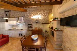 a kitchen and dining room with a table and a television at Le Tradizioni Casa Vacanze in Trevi