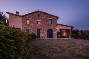 a large brick house with its lights on at Podere San Pasquale - La Vigna in Castiglione dʼOrcia
