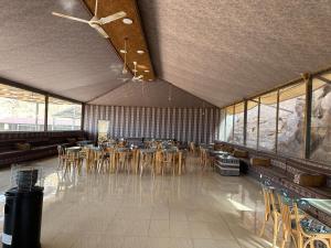 a dining room with tables and chairs and windows at Night Magic Camp in Wadi Rum
