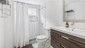 a white bathroom with a toilet and a sink at Historic New Orleans in the Treme in New Orleans