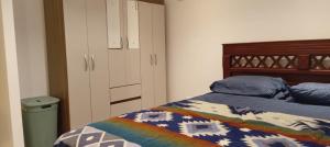 Un dormitorio con una cama con un edredón colorido. en Ricks place, en Guayaquil