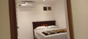 Un dormitorio con una cama en una habitación blanca. en Ricks place, en Guayaquil