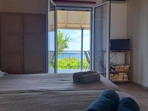 a bedroom with a bed with a view of a balcony at BIZOS Beach in Koroni