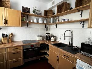 a kitchen with wooden cabinets and a sink at Ferienwohnung Nauen Familie Renner in Nauen