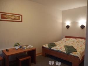 a small bedroom with a bed and a table at Parks Guest House in Sigulda
