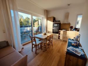 a living room with a table and chairs and a kitchen at Plüschmors in Wittmund