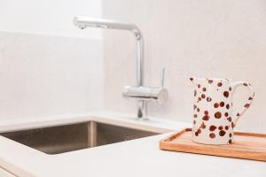 una tazza a pois appoggiata su un tagliere accanto al lavandino di GuestReady - A peaceful home near downtown a Porto
