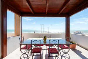 a table and chairs on a balcony with a view of the beach at Ostia Attico fronte mare in Lido di Ostia