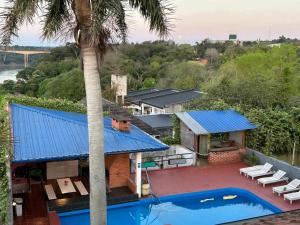 伊瓜苏港Guembe al Rio Hostel的带游泳池的房子的鸟瞰图