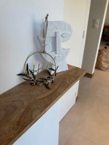 a wreath on top of a counter with a large letter t at La Cour des Princesses in Deauville