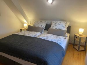 a bedroom with a bed with two pillows and two lamps at Ferienhaus Sonnenterrasse in Gerstenberg