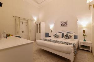 a large white bedroom with a bed and a kitchen at Saroja Heritage, Varanasi in Varanasi