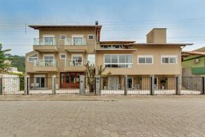 a large house with a fence in front of it at Residencial Casa Flora in Bombinhas