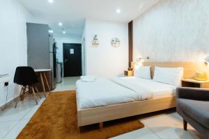 a bedroom with a large bed and a couch at Modern Studio Suite at The Gallery in Accra +8 photos