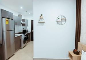 a kitchen with a stainless steel refrigerator and a dishwasher at Modern Studio Suite at The Gallery in Accra