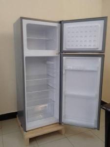 an empty refrigerator with its door open in a kitchen at Gillian's Place - 3 Bedrooms in Dar es Salaam