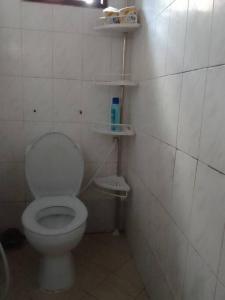 a bathroom with a white toilet and shelves on the wall at Gillian's Place - 3 Bedrooms in Dar es Salaam +27 photos