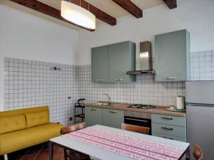 a kitchen with a table and a yellow couch at Corte Vitelleria in Piazza