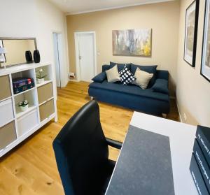 a living room with a blue couch and a table at FeWo Uettingen Mitte in Uettingen