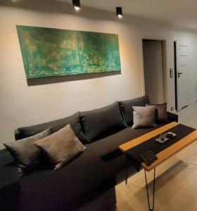 a living room with a black couch and a table at No71 The Luxury Apartment in Głogów