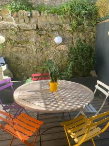 a table with chairs and a potted plant on a patio at Soleil de Sète, maison coquette en cœur de ville in Sète