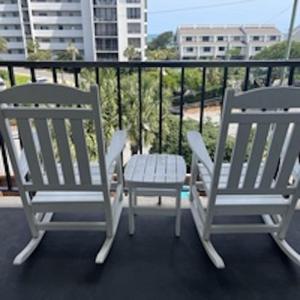 two chairs and a table on a balcony at Summer Sands - 303 by Sea Scape Properties in Wrightsville Beach +4 photos
