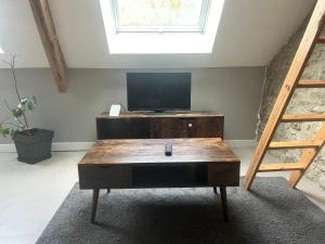a living room with a tv and a wooden coffee table at Séjour au Domaine des mortiers in Saint-Étienne-de-Montluc