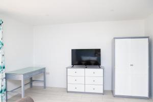 Televízia a/alebo spoločenská miestnosť v ubytovaní Sugarmon Villas