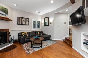 a living room with a black couch and a tv at Three Ridges 74 with Wintergreen Advantage in Wintergreen