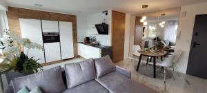 a living room with a couch and a kitchen with a table at Apartament 100-Brawa 26 in Kluczbork