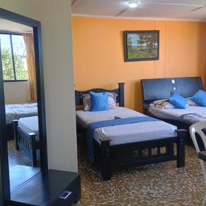 a room with two beds and a mirror at Hotel Villa Giron inn in Barranquilla +97 photos