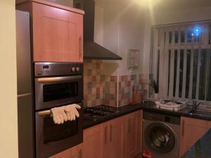 a kitchen with a stove top oven next to a sink at Komegloba Exquisite room in Manchester +36 photos