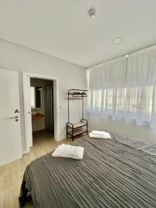 a bedroom with a large bed with two white towels at Solmar Alojamentos in Ponta Delgada