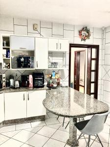 a kitchen with a large marble table and chairs at Casa em Blumenau in Blumenau +6 photos