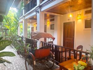 a carriage on the porch of a house at Golden Sun Boutique Hotel in Luang Prabang