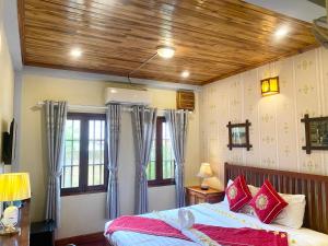 a bedroom with a bed with blue and red pillows at Golden Sun Boutique Hotel in Luang Prabang