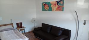 a living room with a black couch and a bed at Ferienwohnung Unter der Limburg in Bad Dürkheim-Hausen in Bad Dürkheim